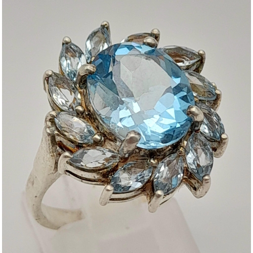 1216 - A 925 Silver Blue Gemstone Ring. Floral design. Size P.