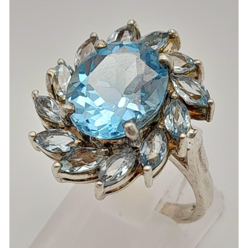 1216 - A 925 Silver Blue Gemstone Ring. Floral design. Size P.