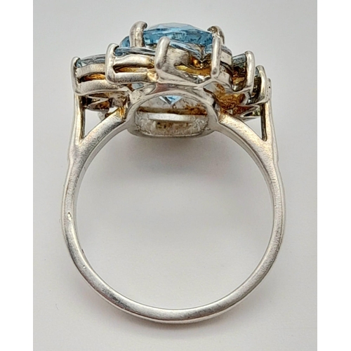 1216 - A 925 Silver Blue Gemstone Ring. Floral design. Size P.