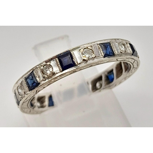 251 - An 18 K white gold diamond and sapphire, eternity ring, mil-grain edges,  hand engraved side and rop... 