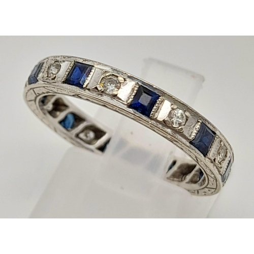 251 - An 18 K white gold diamond and sapphire, eternity ring, mil-grain edges,  hand engraved side and rop... 