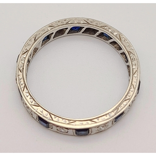 251 - An 18 K white gold diamond and sapphire, eternity ring, mil-grain edges,  hand engraved side and rop... 