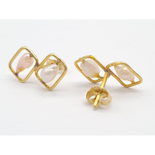 664 - A 14 K yellow gold pair of stud earrings with pearls. Total weight: 1.6 g.