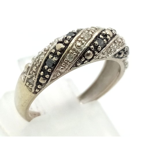 910 - 9K WHITE GOLD BLACK & WHITE DIAMOND BAND RING. TOTAL WEIGHT 2.2G SIZE L