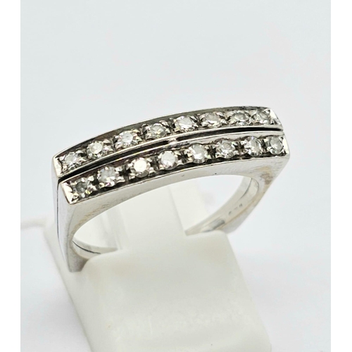 1136 - An 18 K white gold ring with two bands of white sapphires. Ring size: O, weight: 4.6 g.