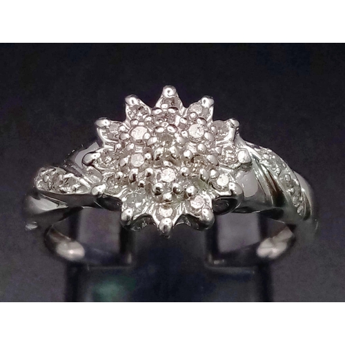 654 - 9k white gold diamond cluster ring with twist shoulders. 0.20ct Diamond. Total Weight 2.7g, size M