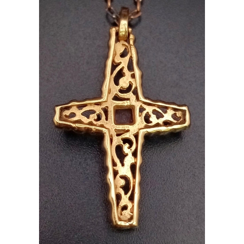 181 - A vintage, 18 K yellow gold intricately carved cross with a ruby cabochon, on a gold chain. Cross di... 