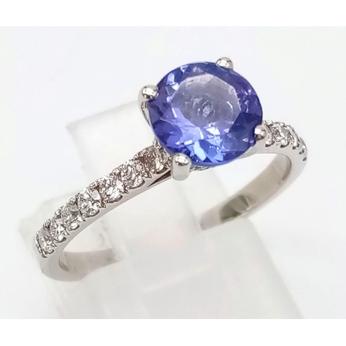 68 - PLATINUM DIAMOND & TANZANITE RING, WITH A 1.40CT ROUND TANZANITE CENTRE AND DIAMOND SET SHOULDERS. W... 