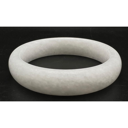 956 - A Chinese White Jade Bangle. 56mm inner diameter. 16mm width.