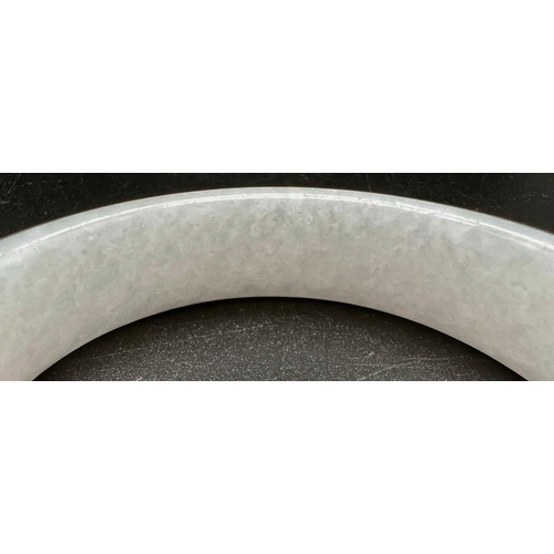 956 - A Chinese White Jade Bangle. 56mm inner diameter. 16mm width.