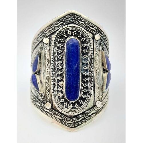 373 - A Lapis Lazuli Cuff Bangle. Set in white metal. 8.5cm at widest point.