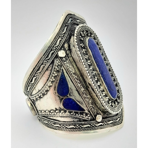373 - A Lapis Lazuli Cuff Bangle. Set in white metal. 8.5cm at widest point.