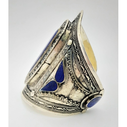 373 - A Lapis Lazuli Cuff Bangle. Set in white metal. 8.5cm at widest point.