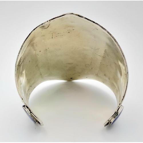 373 - A Lapis Lazuli Cuff Bangle. Set in white metal. 8.5cm at widest point.