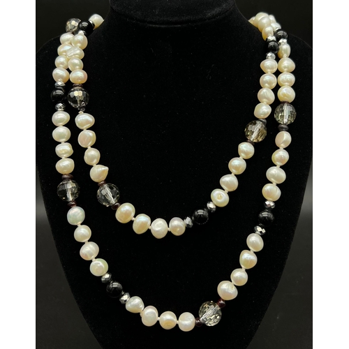 451 - A Cultured Freshwater Pearl and Onyx Rope Length Necklace. 110cm