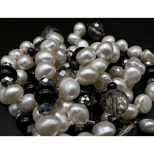 451 - A Cultured Freshwater Pearl and Onyx Rope Length Necklace. 110cm