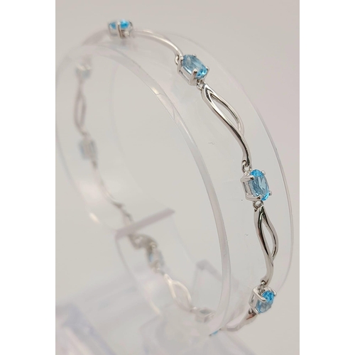 48 - A 9K White Gold Blue Topaz Bracelet. Eight ice-blue topaz gemstones. 18cm. 4.57g total weight