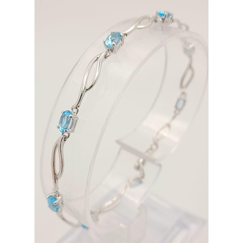 48 - A 9K White Gold Blue Topaz Bracelet. Eight ice-blue topaz gemstones. 18cm. 4.57g total weight