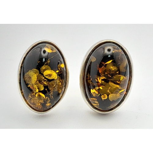 780 - A Vintage Pair of Sterling Silver Amber Set Stud Different Earrings. Oval Cut 1.4cm Length.