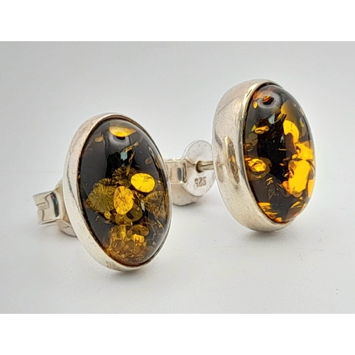 780 - A Vintage Pair of Sterling Silver Amber Set Stud Different Earrings. Oval Cut 1.4cm Length.