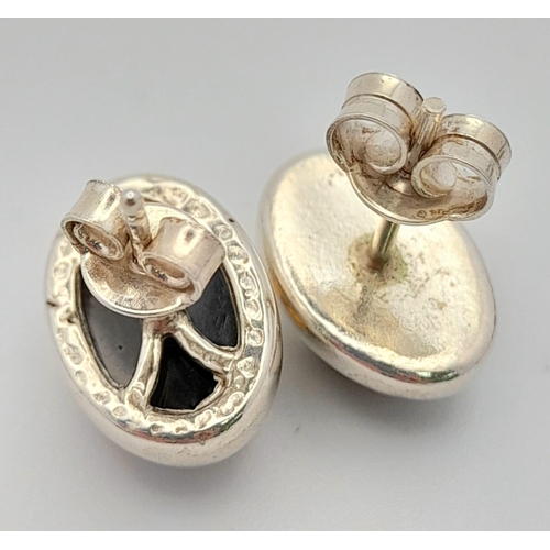 780 - A Vintage Pair of Sterling Silver Amber Set Stud Different Earrings. Oval Cut 1.4cm Length.