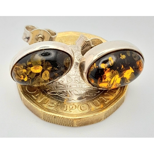 780 - A Vintage Pair of Sterling Silver Amber Set Stud Different Earrings. Oval Cut 1.4cm Length.