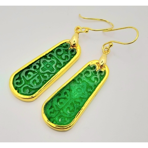911 - A Pair of Jade Drop Earrings. Gilded and pierced decoration.
Pendant shape. 4cm drop