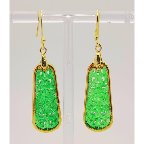 911 - A Pair of Jade Drop Earrings. Gilded and pierced decoration.
Pendant shape. 4cm drop