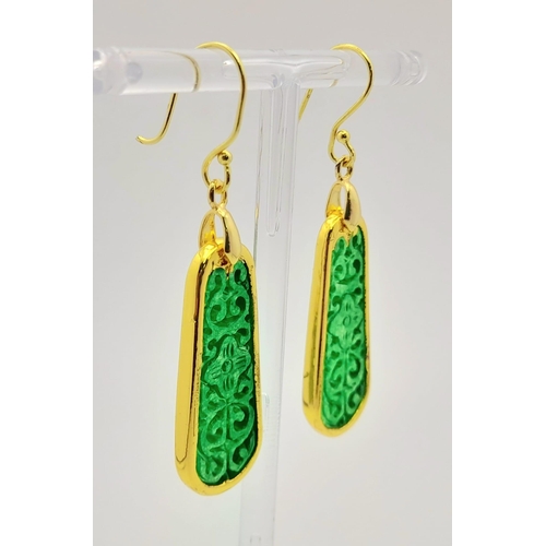 911 - A Pair of Jade Drop Earrings. Gilded and pierced decoration.
Pendant shape. 4cm drop