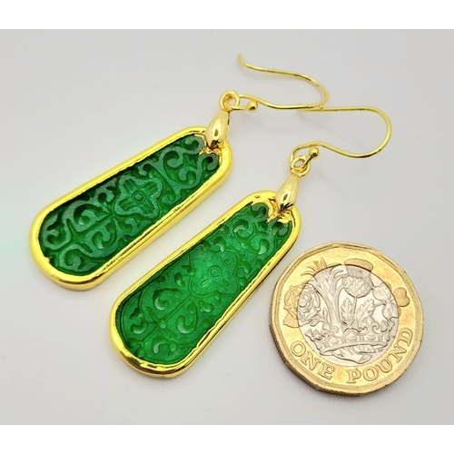 911 - A Pair of Jade Drop Earrings. Gilded and pierced decoration.
Pendant shape. 4cm drop