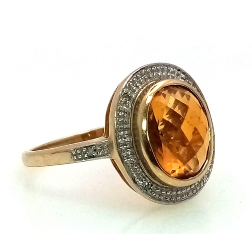 387 - A 9K Yellow Gold Citrine and Diamond Ring. Central faceted, rich, clean citrine with a diamond halo.... 