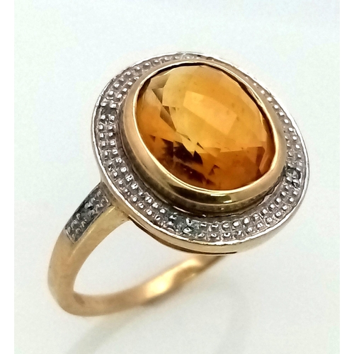 387 - A 9K Yellow Gold Citrine and Diamond Ring. Central faceted, rich, clean citrine with a diamond halo.... 