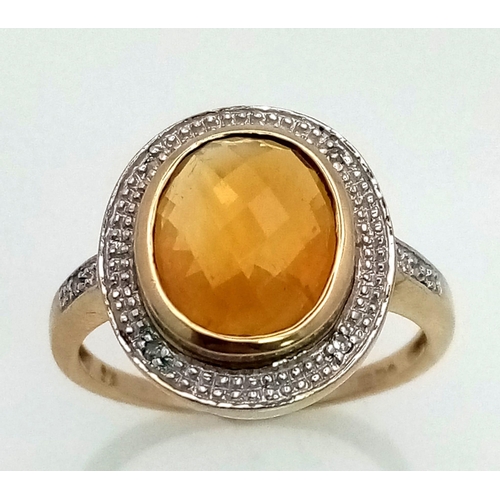 387 - A 9K Yellow Gold Citrine and Diamond Ring. Central faceted, rich, clean citrine with a diamond halo.... 