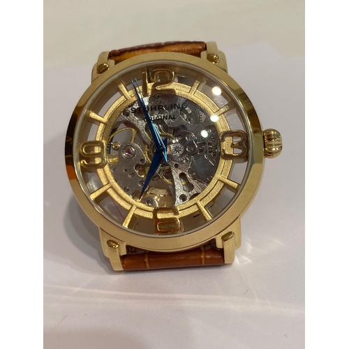 49 - Genuine STUHRLING of NEW YORK AUTOMATIC SKELETON WATCH. Blue hands model finished in gold plated sta... 