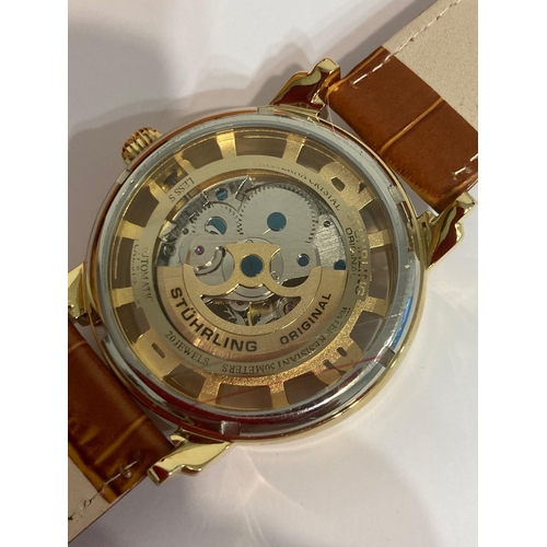 49 - Genuine STUHRLING of NEW YORK AUTOMATIC SKELETON WATCH. Blue hands model finished in gold plated sta... 