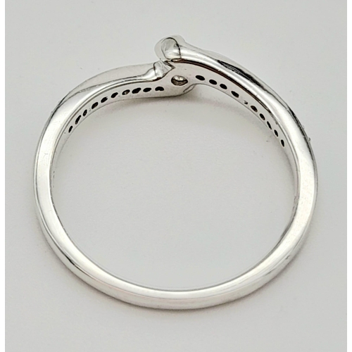 645 - 9K WHITE GOLD DIAMOND TWIST BAND RING. 0.20CT DIAMOND. TOTAL WEIGHT 2.1G. SIZE N