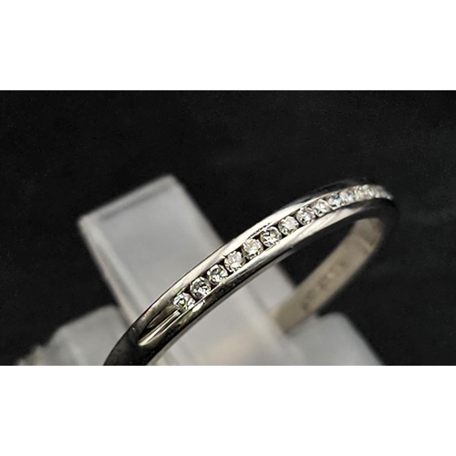 470 - 18k white gold channel set diamond half eternity ring (dia:0.20ct) 1.76g, size M