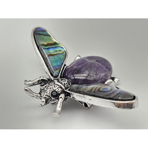 444 - An Amethyst Bee Brooch with Decorative Shell Wings. Wingspan - 5cm. On white metal.