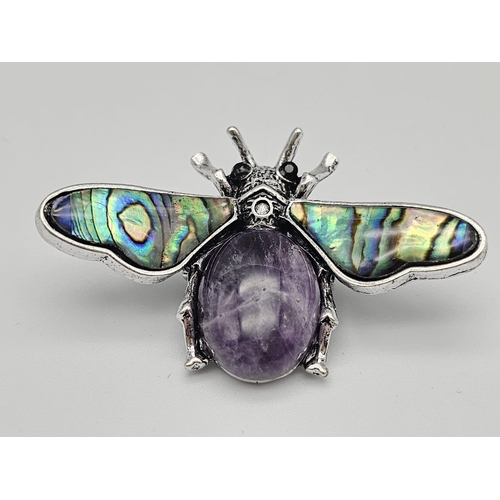 444 - An Amethyst Bee Brooch with Decorative Shell Wings. Wingspan - 5cm. On white metal.