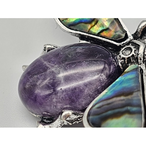 444 - An Amethyst Bee Brooch with Decorative Shell Wings. Wingspan - 5cm. On white metal.