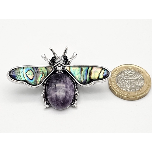 444 - An Amethyst Bee Brooch with Decorative Shell Wings. Wingspan - 5cm. On white metal.