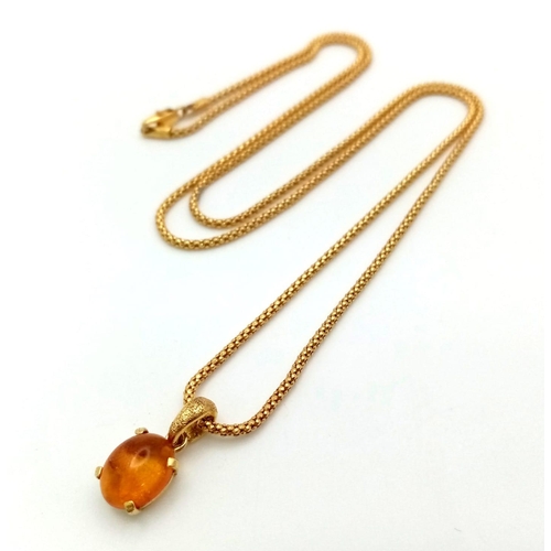 774 - AN 18K GOLD AND AMBER PENDANT ON AN 18K GOLD 58cms  TWIST CHAIN .   8.1gms