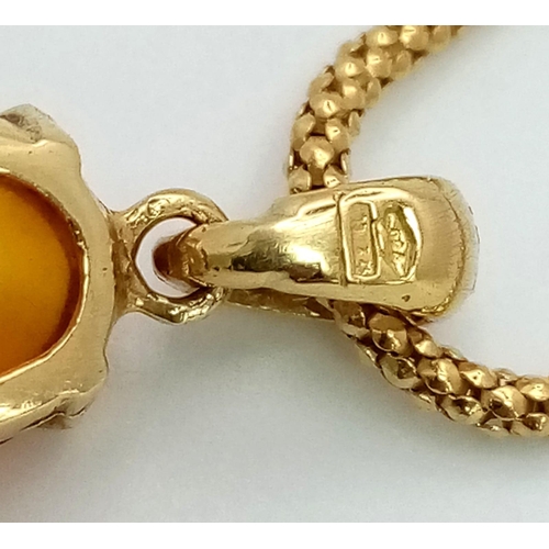 774 - AN 18K GOLD AND AMBER PENDANT ON AN 18K GOLD 58cms  TWIST CHAIN .   8.1gms