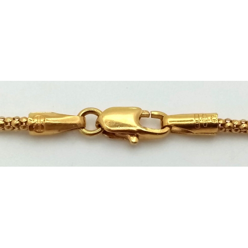 774 - AN 18K GOLD AND AMBER PENDANT ON AN 18K GOLD 58cms  TWIST CHAIN .   8.1gms