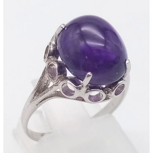 918 - AN AMETHYST CABOCHON SET IN 9K WHITE GOLD .  3.1gms   size N