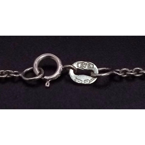 634 - A 9K WHITE GOLD PENDANT WITH A PEARL , HEART AND A CROSS CHARM ON A 40cms chain .   4.5gms    ref 90... 