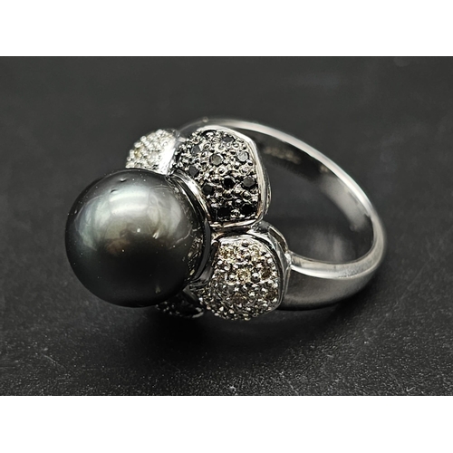 64 - An 18K White Gold, Diamond and Tahitian South Sea Pearl Ring. Large, beautiful central pearl (12mm) ... 