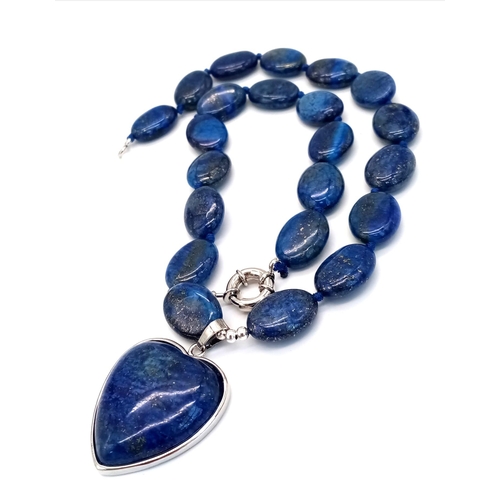 914 - A Lapis Lazuli Heart Pendant on a Lapis Lazuli Oval Bead Necklace. 4cm and 46cm. Oval beads - 17mm.
