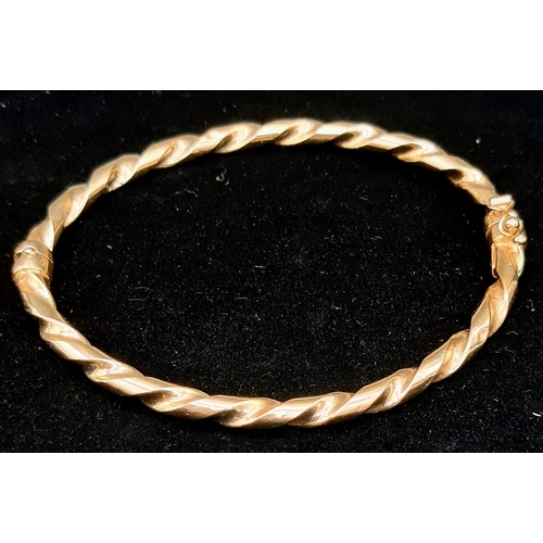 22 - A Vintage 9K Yellow Gold Twist Bangle with Clip-Open Clasp and Tension Features. 5.11g