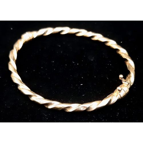 22 - A Vintage 9K Yellow Gold Twist Bangle with Clip-Open Clasp and Tension Features. 5.11g